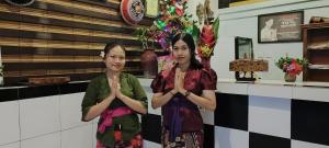 two women standing in front of a counter with their hands folded at 1000 Dream Bungalow in Lovina