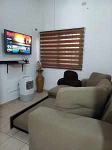 uma sala de estar com um sofá e uma televisão de ecrã plano em Descansa como en casa em San Miguel