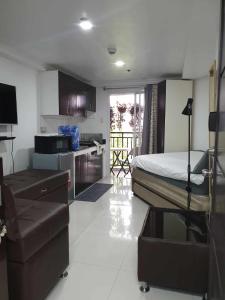 ein Schlafzimmer mit einem Bett und eine Küche mit einem Tisch in der Unterkunft Baguio Bliss by Burnham Hill Condominium in Baguio City
