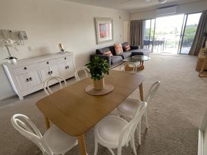 ein Wohnzimmer mit einem Tisch, Stühlen und einem Sofa in der Unterkunft Rovera Apartments in Maroochydore