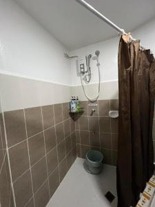ein Bad mit einer Dusche und einem WC in der Unterkunft Baguio Bliss by Burnham Hill Condominium in Baguio City