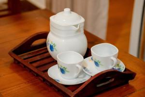 a tea pot and three cups on a wooden tray at AGP Greeny View Resident in Galle +39 photos