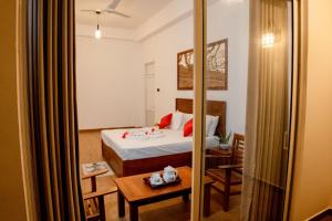 a hotel room with a bed and a mirror at AGP Greeny View Resident in Galle