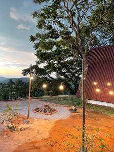 a fire pit in a field with a tree at Chalé Panorama in Munhoz