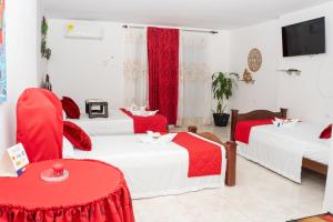 een hotelkamer met 2 bedden met rode en witte dekens bij La Niña Mire in Puerto Colombia