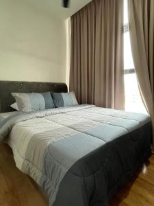 a large bed in a bedroom with a window at Roxy Apartment Kuching in Kuching