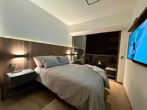 a bedroom with a bed and a flat screen tv at Apartamento vista al mar, Barranco, The Modern in Lima