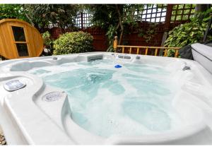 a jacuzzi tub filled with water in a yard at Nature's Serenade:3BR Classic Home-Jacuzzi & Sauna in Canvey Island