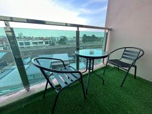 a table and two chairs on a balcony with a view at Roxy Apartment Kuching in Kuching