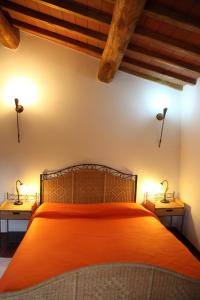 ein Schlafzimmer mit einem orangenen Bett mit zwei Nachttischen in der Unterkunft Tiberio in Loro Ciuffenna