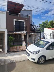 un coche blanco estacionado frente a una casa en La Luna, en Cancún