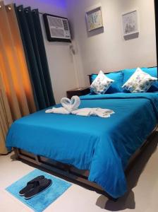 - un lit bleu avec des serviettes dans l'établissement Quiet and spacious condo wid fast internet connection with Netflix, à Davao