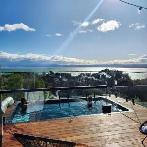 a swimming pool on a deck with a view of the water at black + shack in Coles Bay