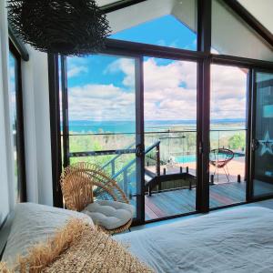 a bedroom with a bed and a view of the ocean at black + shack in Coles Bay