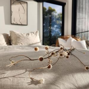a bed with a bunch of dried flowers on it at black + shack in Coles Bay +27 photos