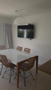 een eettafel met stoelen en een tv aan de muur bij Green Park Propietarios in Punta del Este