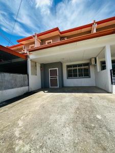 a house with an empty driveway in front of it at Macagawa Homestay in Tawau