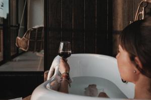 a woman holding a glass of wine in a bath tub at black + shack in Coles Bay +27 photos