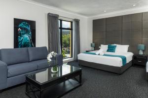 a hotel room with a bed and a couch at The Abbott Boutique Hotel in Cairns