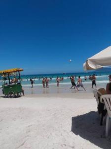 un grupo de personas jugando en la playa en Ampla casa de praia em cabo frio, en Cabo Frío