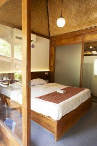 ein Schlafzimmer mit einem Bett mit einem Holzrahmen in der Unterkunft puunee guest house & restaurant in Mendut