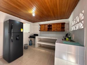 a kitchen with a refrigerator and a wooden ceiling at Casa Tamarielys in Cartagena de Indias