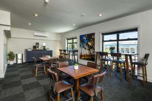 un restaurante con mesas y sillas y un bar en The Abbott Boutique Hotel en Cairns