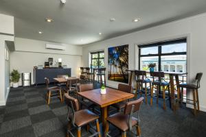 a restaurant with tables and chairs and a bar at The Abbott Boutique Hotel in Cairns