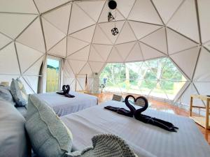 two black swans sitting on a couch in a yurt at ไร่ไปรยา แก่งกระจาน in Ban Wang Malako