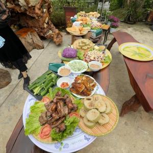 una mesa con platos de comida. en Na Tranh Ecolodge, en Thái Nguyên