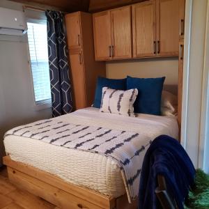 uma cama num pequeno quarto com armários de madeira em Lake Front cottage em Little Elm