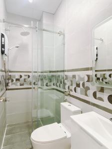 a bathroom with a toilet and a glass shower at SAIGONESE Studio in Ho Chi Minh City