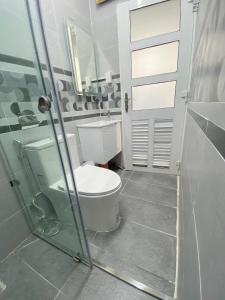 a bathroom with a toilet and a glass shower door at SAIGONESE Studio in Ho Chi Minh City