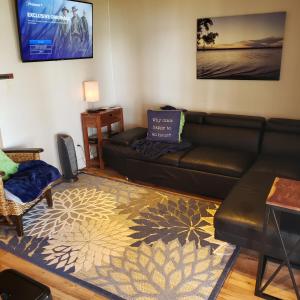a living room with a leather couch and a rug at Lake Front cottage in Little Elm