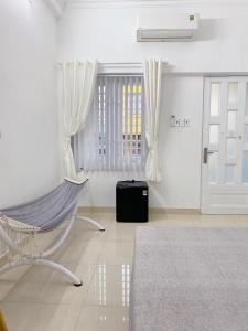 ein weißes Zimmer mit einer Hängematte und einer Tür in der Unterkunft SAIGONESE Studio in Ho-Chi-Minh-Stadt