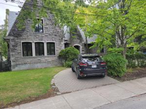 a car parked in front of a stone house at Amazing 8BR Suites Waterview House & SPA in Montréal
