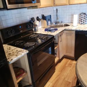 a kitchen with a black stove and a sink at Lake Front cottage in Little Elm