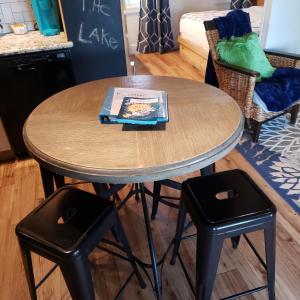 a table with two stools and a table with a book on it at Lake Front cottage in Little Elm
