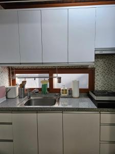 首爾的住宿－Lotus Stay，厨房配有白色橱柜和水槽