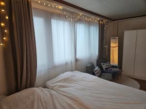 首爾的住宿－Lotus Stay，卧室配有床、椅子和窗户。