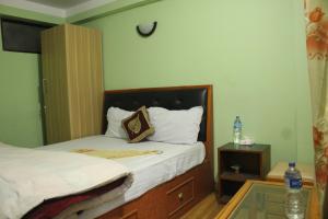 um pequeno quarto com uma cama e uma mesa de vidro em Mountain Guesthouse em Bhaktapur