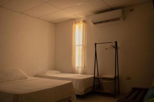 a small room with two beds and a window at Portofino in Playa San Blas