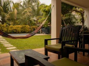 a hammock on the porch of a house with a yard at Portofino in Playa San Blas