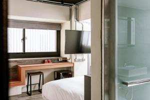um quarto de hotel com uma cama e uma televisão em Saturn Hotel em Taichung