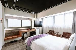 um quarto com uma cama e uma televisão de ecrã plano em Saturn Hotel em Taichung