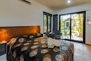 贾比鲁Aurora Kakadu Lodge的一间带大床的卧室和一个阳台