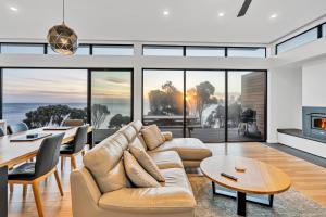 - un salon avec un canapé et une table dans l'établissement Freycinet Coastal Retreat, à Coles Bay