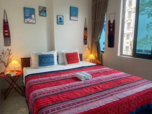 a bedroom with a large bed with a red blanket at Ha Giang Yolo House and Loop Tours in Ha Giang