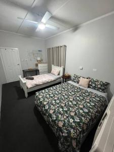 um quarto com uma cama, uma cama e um sofá em Bet you’ll love butler em Mount Isa