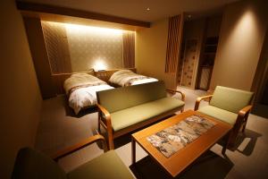 a hotel room with a bed and a table and chairs at 京ごはんと露天風呂の宿 ゆのはな 月や 